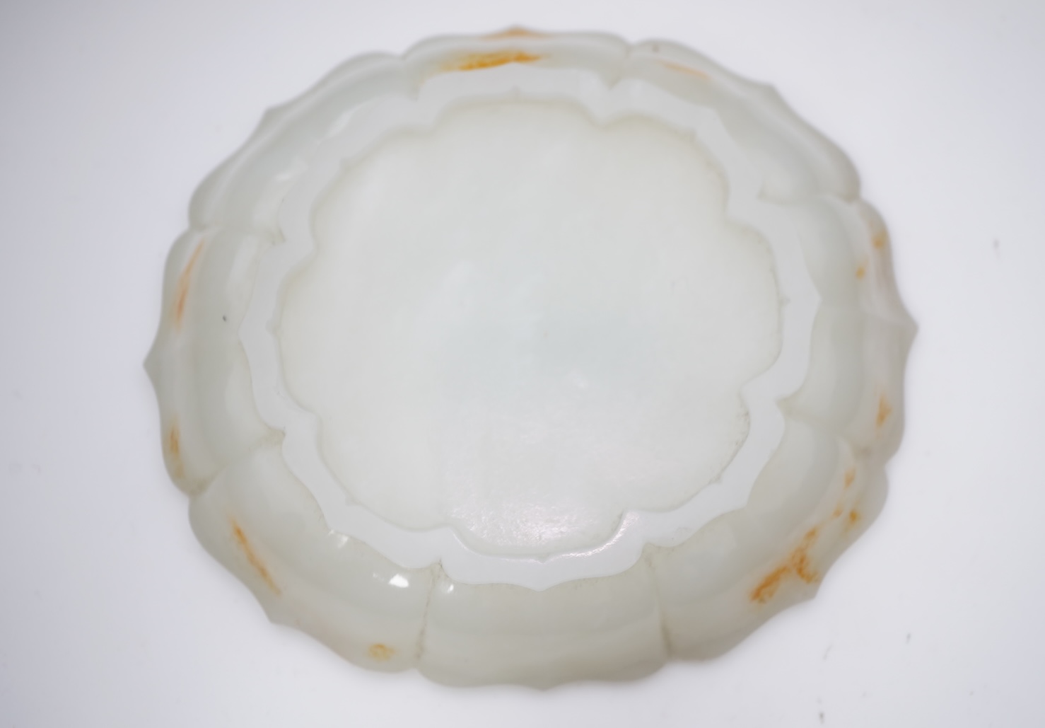 A Chinese white and russet jade petal lobed cup stand